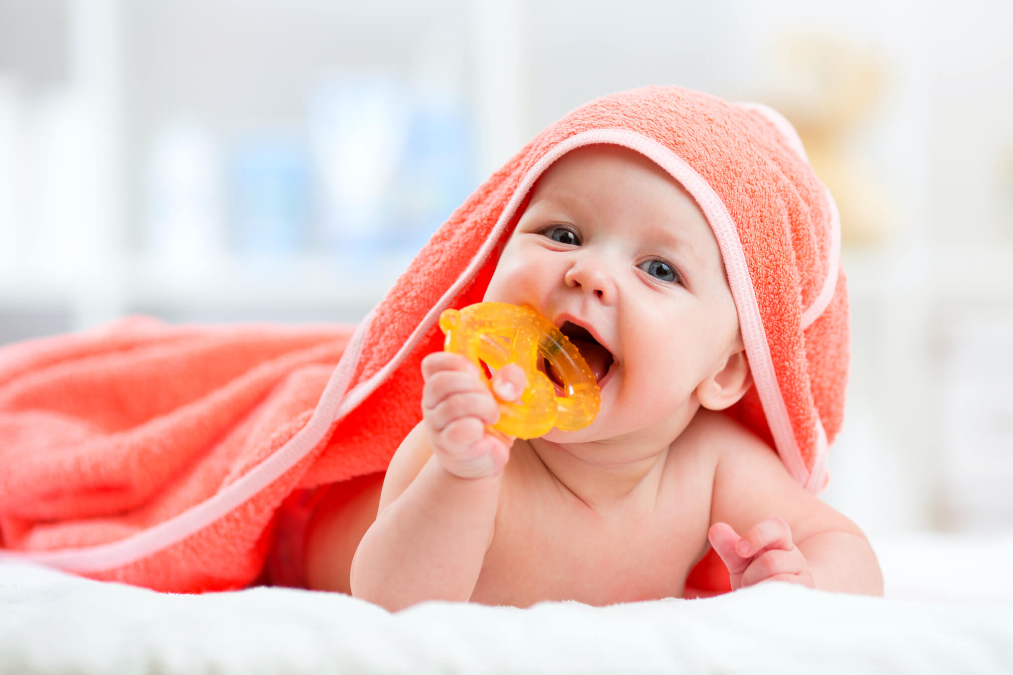 Fotografie novorozence cucající hračku v puse, čímž je vystaven infekci rotaviru.